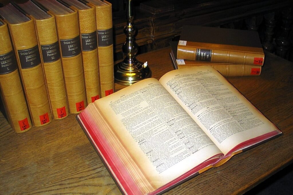 Dictionnaire ancien ouvert sur une table, volumes reliés en arrière-plan