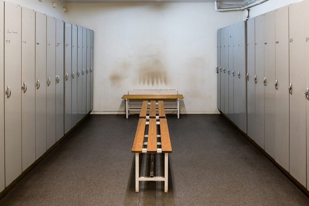 Vestiaire avec casiers métalliques et banc en bois