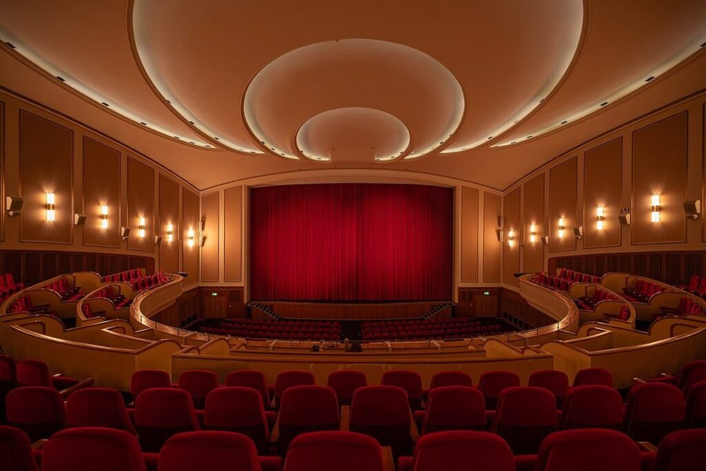 Salle de cinéma Lichtburg à Essen, fauteuils rouges et rideau de scène
